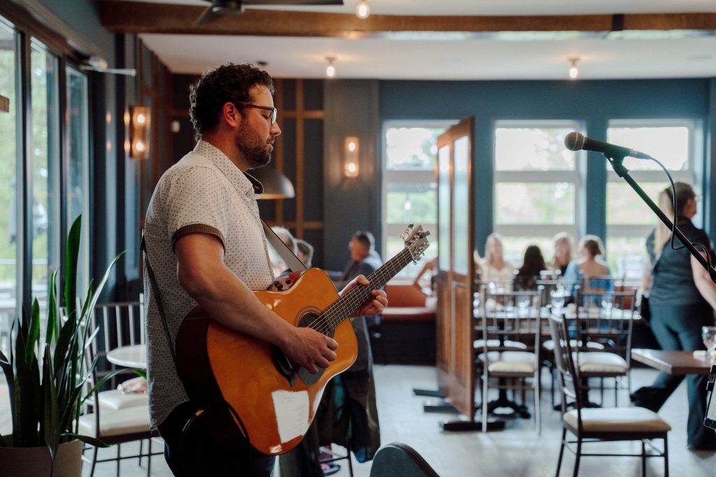 Bradley Kerr playing acoustic guitar in a live setting.